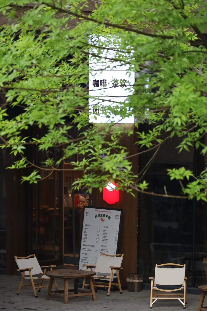 游客坐在京都街角小咖啡馆窗前看雨,手边一杯咖啡