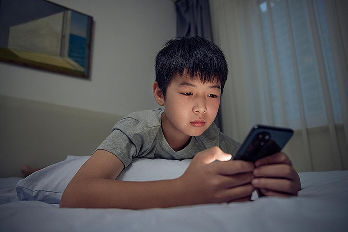 深夜书桌前玩手机的青少年