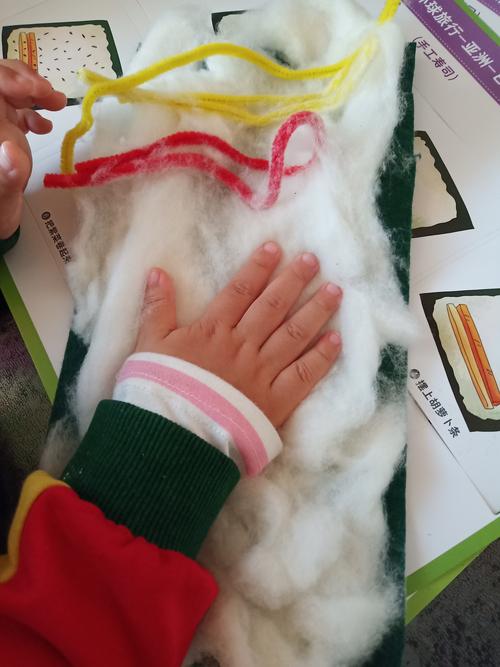 小孩用旧报纸条交错编织小垫子的俯拍视角