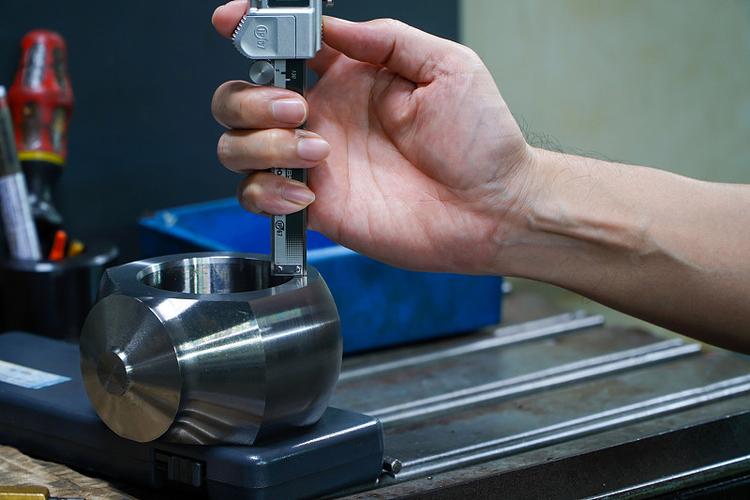 机械加工车间工人手持游标卡尺测量铝合金工件