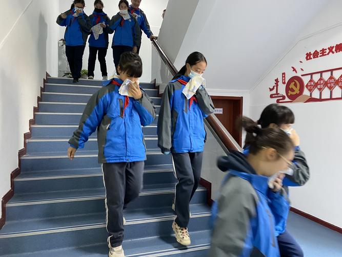 中学走廊消防栓旁站着穿校服的学生和递纸巾的心理老师