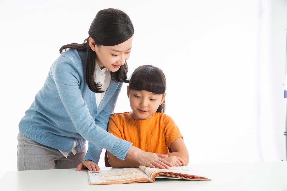 书桌前妈妈跟小孩低头道歉的温馨画面
