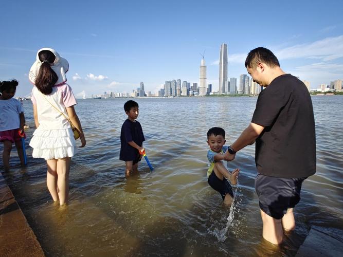 亲子江边散步观察自然场景图