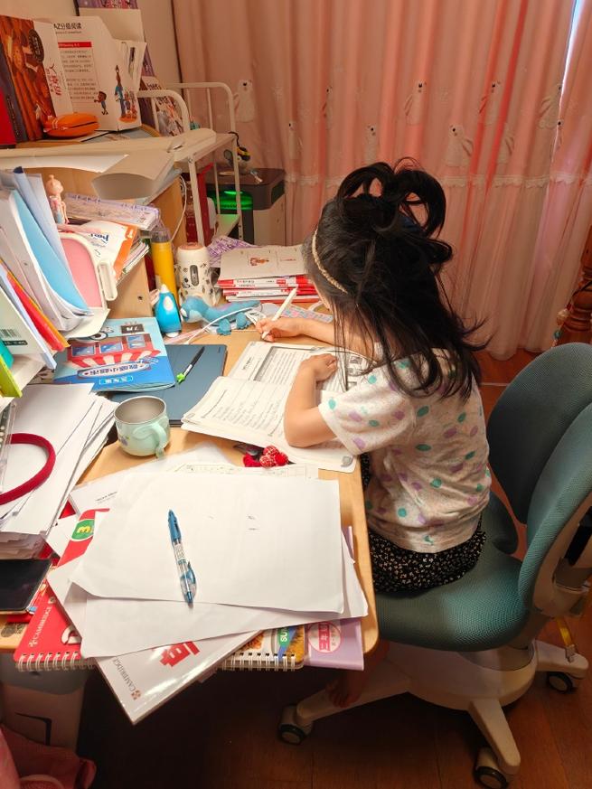 孩子面对杂乱书桌 自己规划学习 表情专注