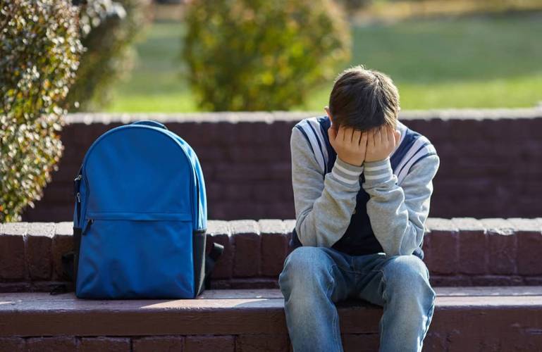 孩子厌学情绪背书包低头站在门口