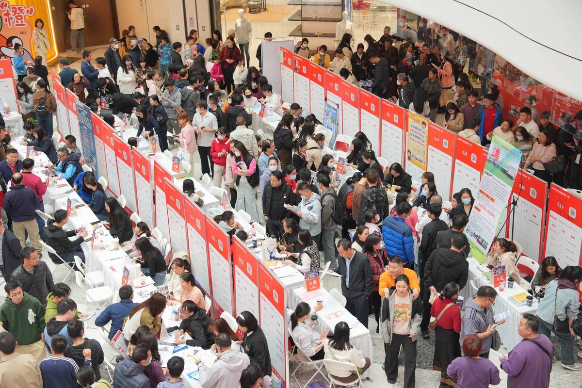 应届生拥挤的招聘会现场求职者看展板