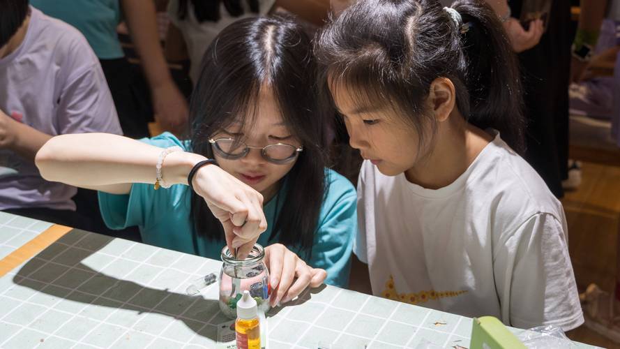 小学科学课小组围坐制作生态瓶场景
