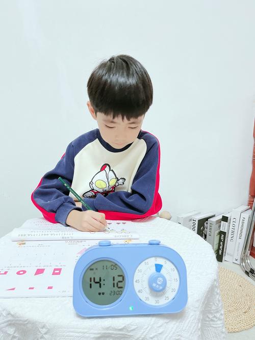 小学男生用计时器挑战自己写作业速度的生活场景