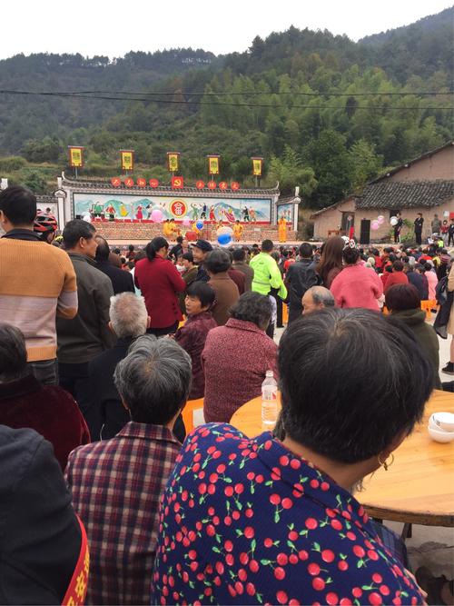 池州刘街傩戏演出前村民围聚在临时戏台边吃蒸米粑