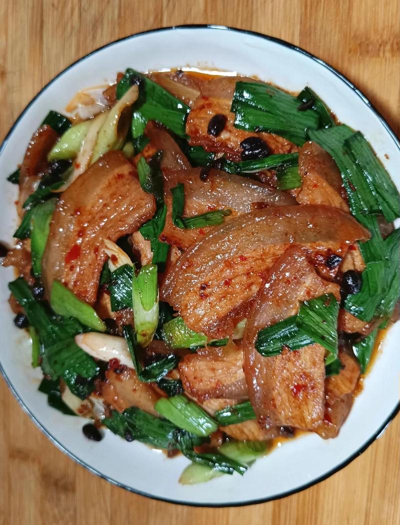 刚出锅的回锅肉特写，灯盏窝状，蒜苗豆豉