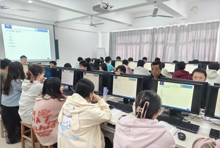 大学生助教在机房辅导同学操作软件的场景