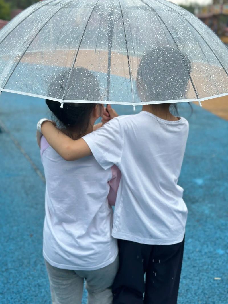 两个孩子和解后共撑一把小雨伞的背影