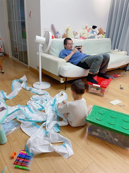 客厅地板上和孩子一起做手工的邋遢父亲
