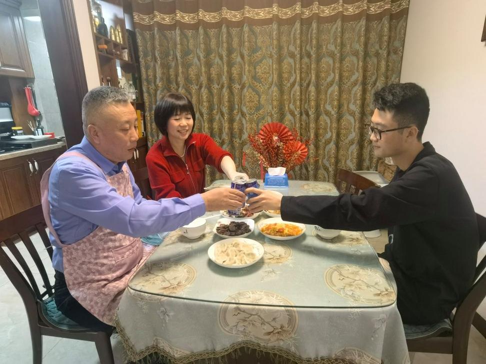 一家三口围坐在餐桌边转矿泉水瓶开家庭会的日常场景