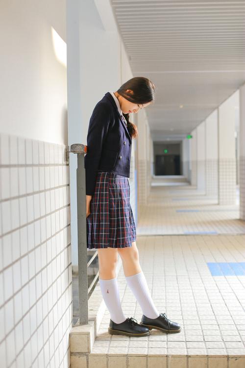 初中走廊穿蓝白校服学生靠栏杆低头攥纸条