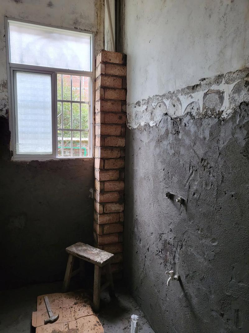 老房拆除后裸露的红砖墙和管道现场图
