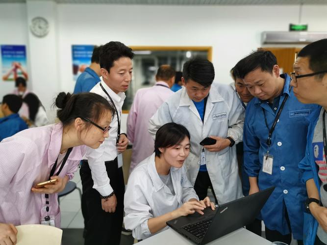 企业技术人员与教授在生产线旁讨论设备参数