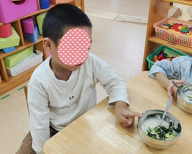 幼儿园小朋友餐桌边敲自己脑袋
