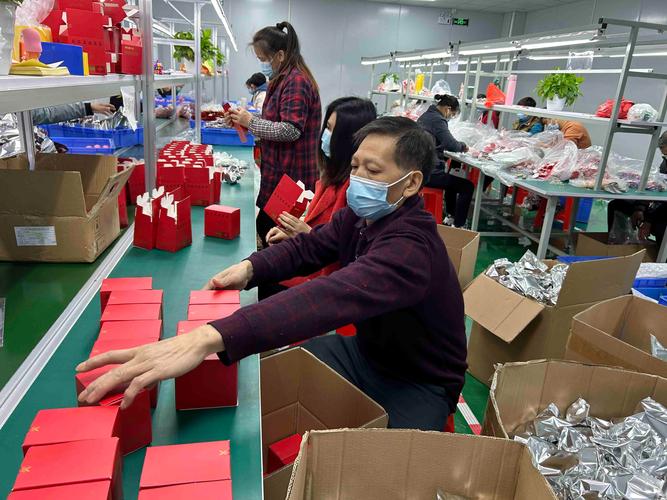 制造业行政在车间门口给员工发开学大礼包现场