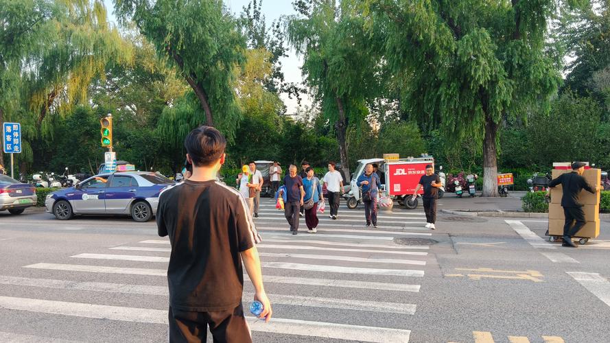 城市人群中一个人停在原地系鞋带的反差照片