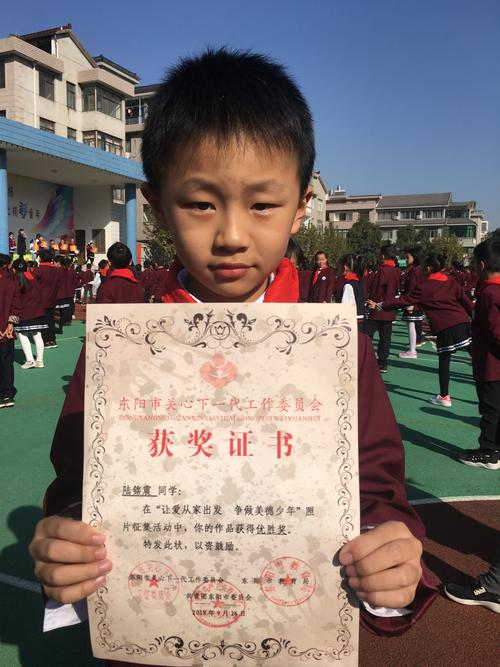 孩子把航模比赛奖状贴在冰箱上的居家场景