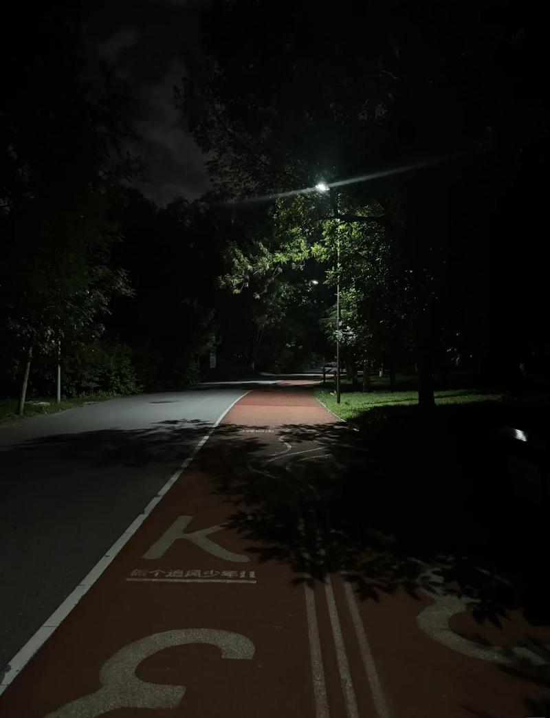 跑步的人影在深夜小区灯光下绕圈