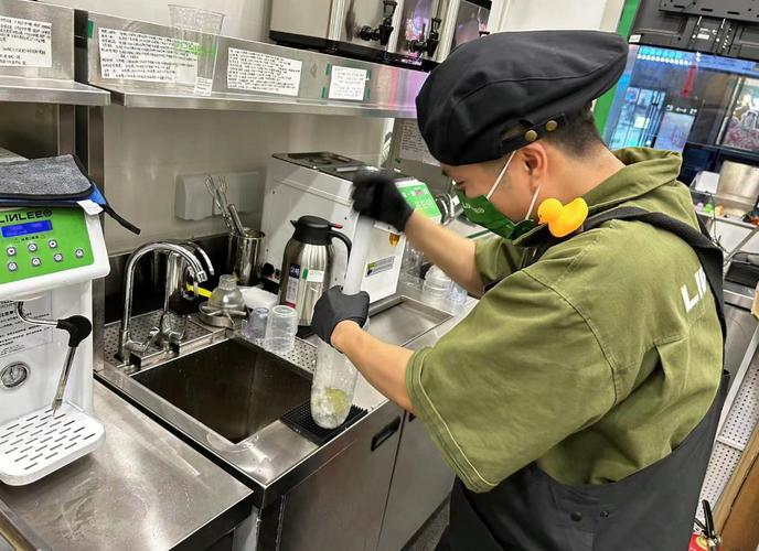 连锁奶茶店员工跟着资深技师练习手打柠檬茶制作