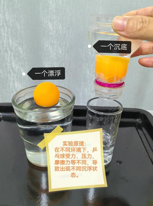 小学科学课上瘪掉的乒乓球沉在装水的烧杯底部的实拍