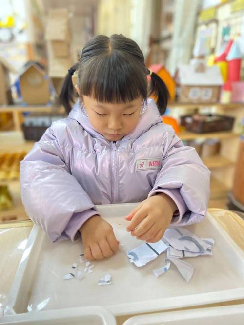 亲子手工后孩子自己收拾桌上碎纸屑