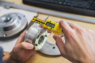 维修师傅用游标卡尺测量ABS轮速传感器间隙作业图