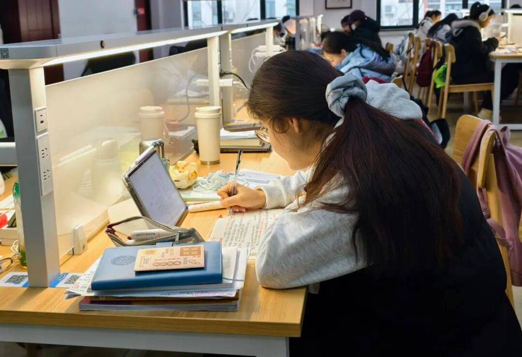 大三学生在图书馆整理课程作业和实习材料的桌面