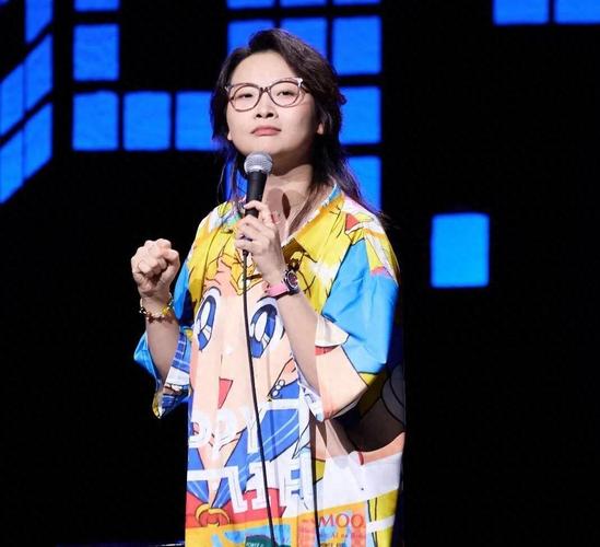 脱口秀演员在舞台上拿着麦克风自嘲式表演近景