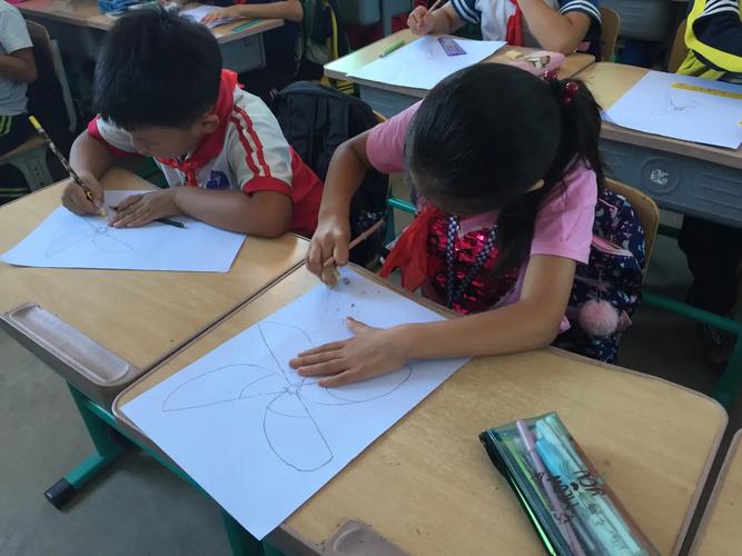 小学早读课上孩子凑着看手绘飞蛾的课桌场景