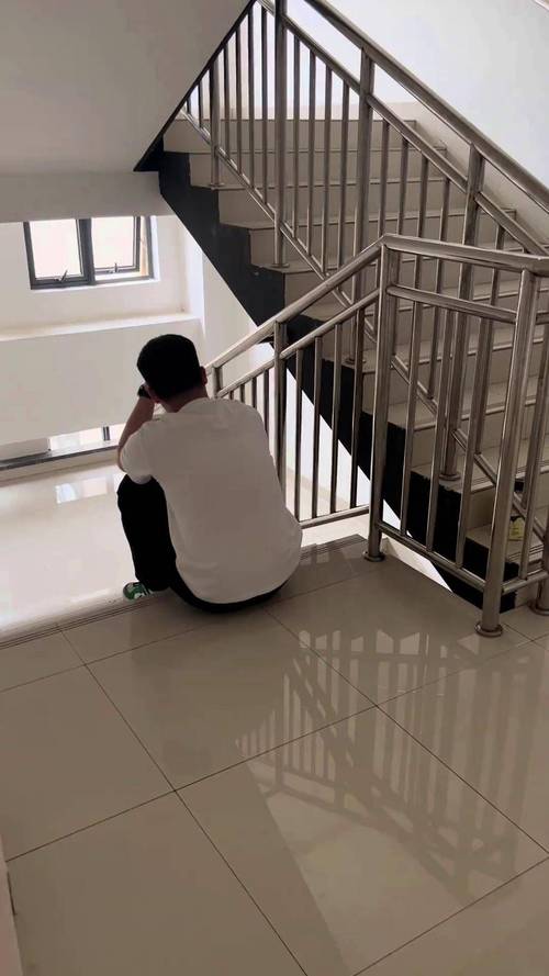成年男子蹲在单元楼楼道捂脸落泪的真实抓拍