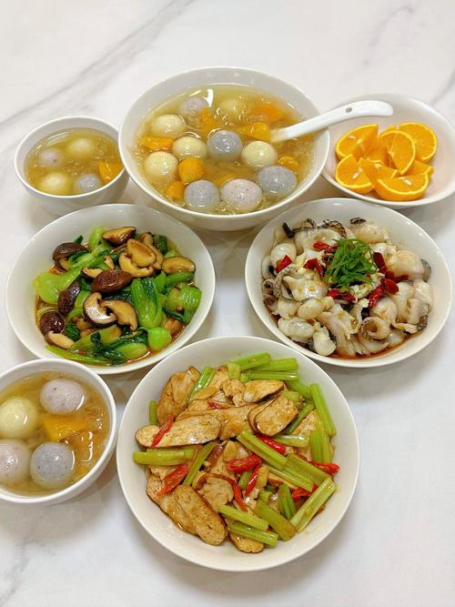家庭餐桌上摆放的清炒时蔬、银耳百合羹、盐焗坚果的日常餐食