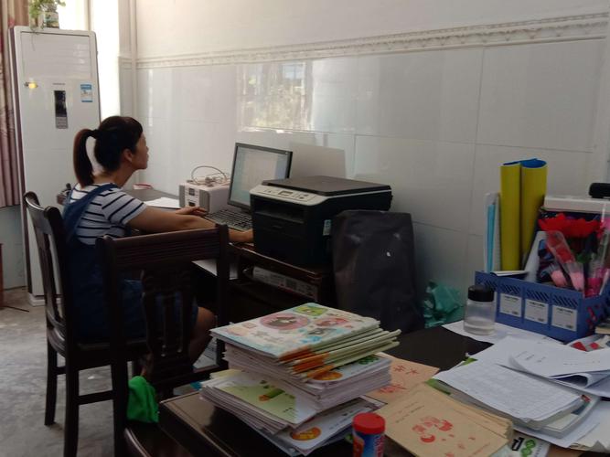 小学班主任在堆满表格的办公桌上疲惫工作