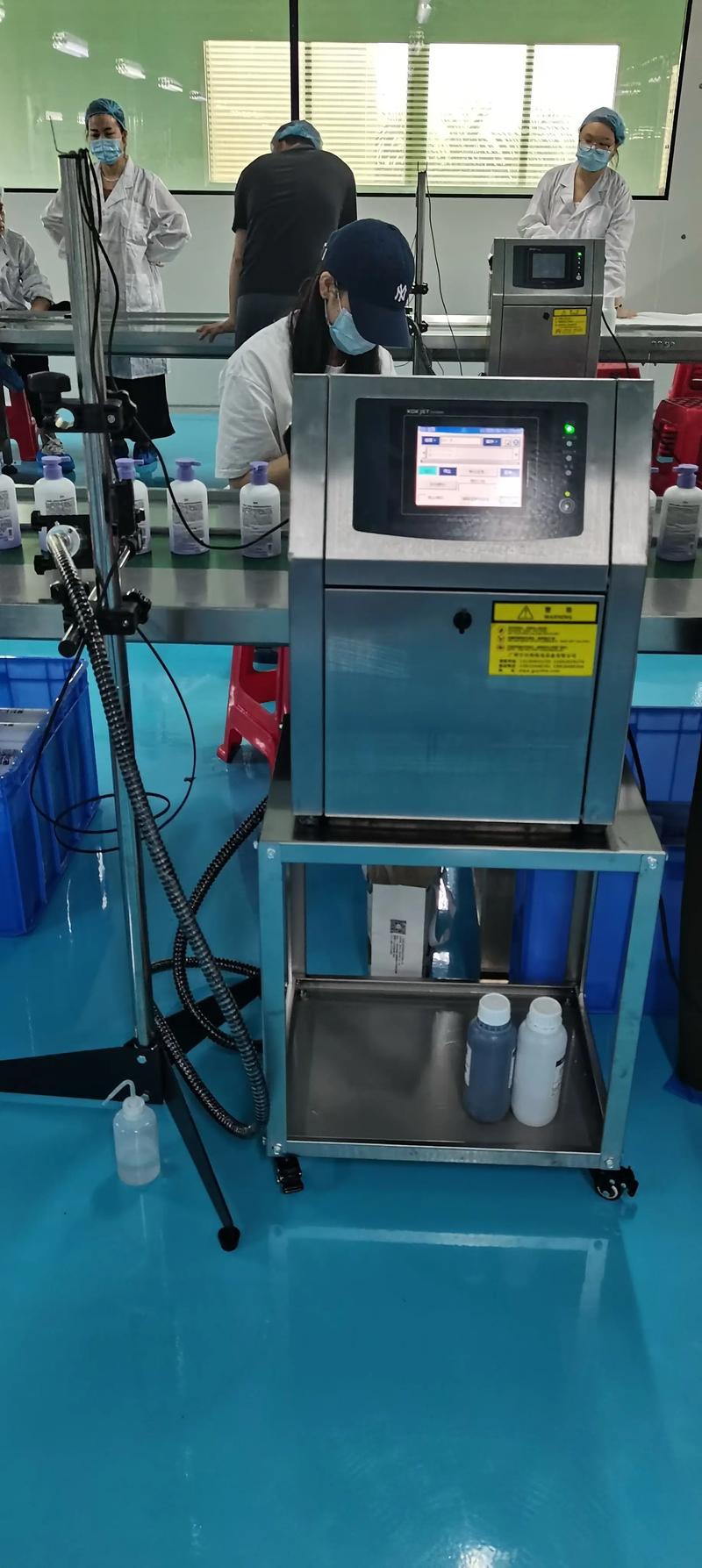 工厂流水线上高速喷码机正在打码生产日期