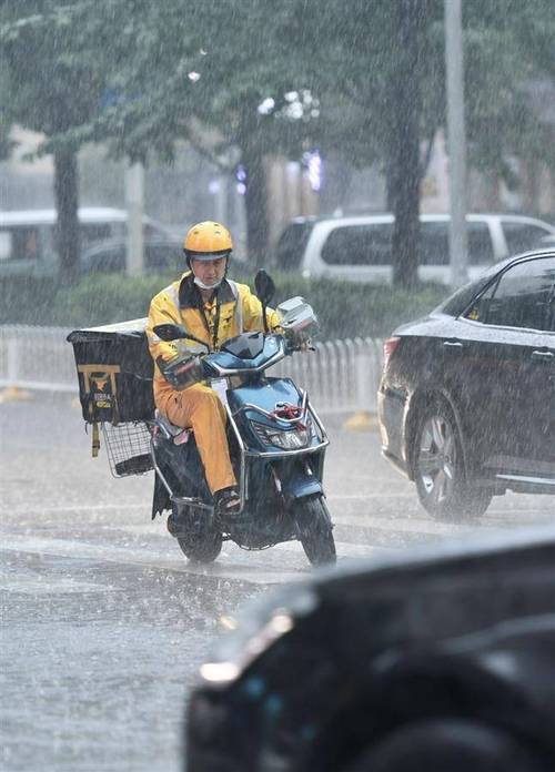外卖骑手雨天在路口等红灯的真实工作场景