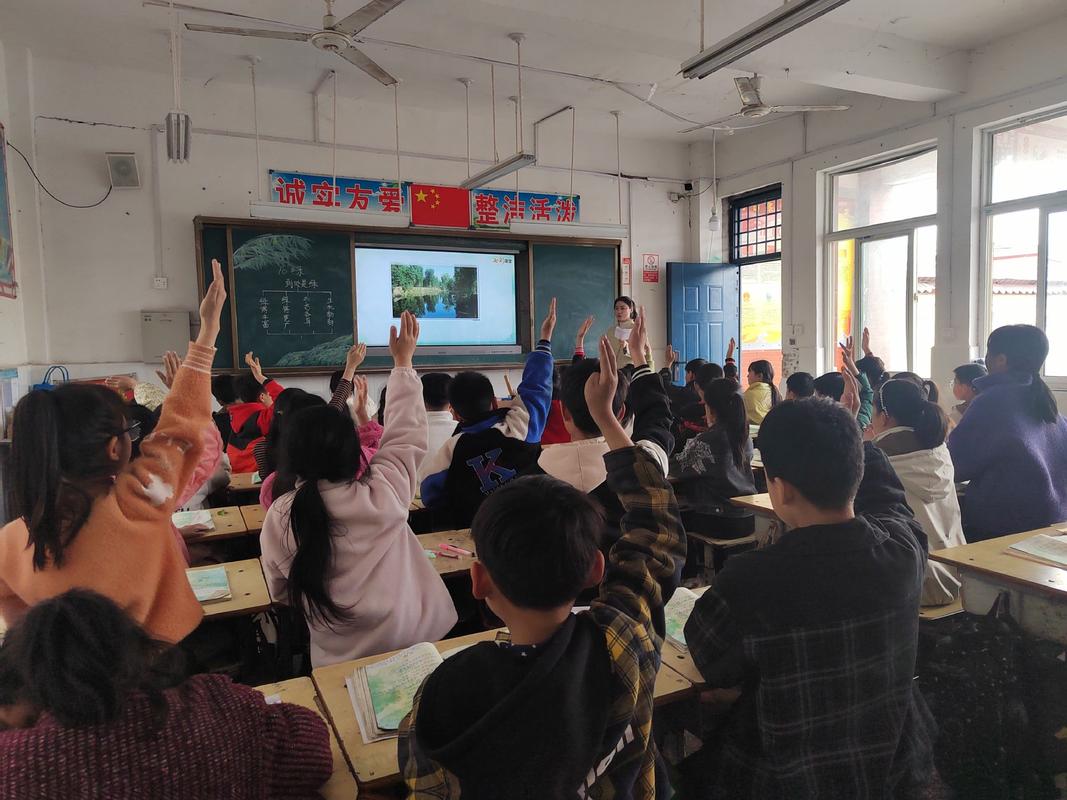 乡镇小学双师课堂学生凑到讲台前举手的实拍