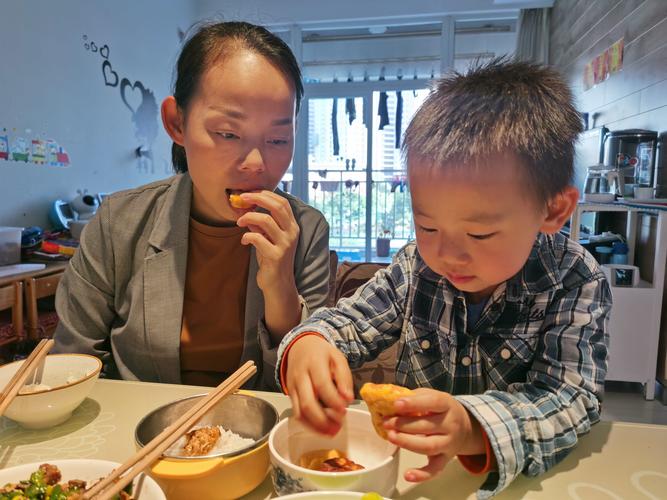 家庭餐桌上孩子低头扒饭家长开口说教的日常画面