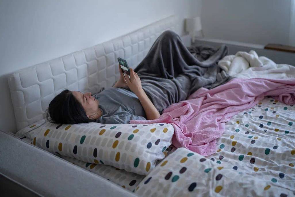 中考后学生瘫在床上玩手机行为