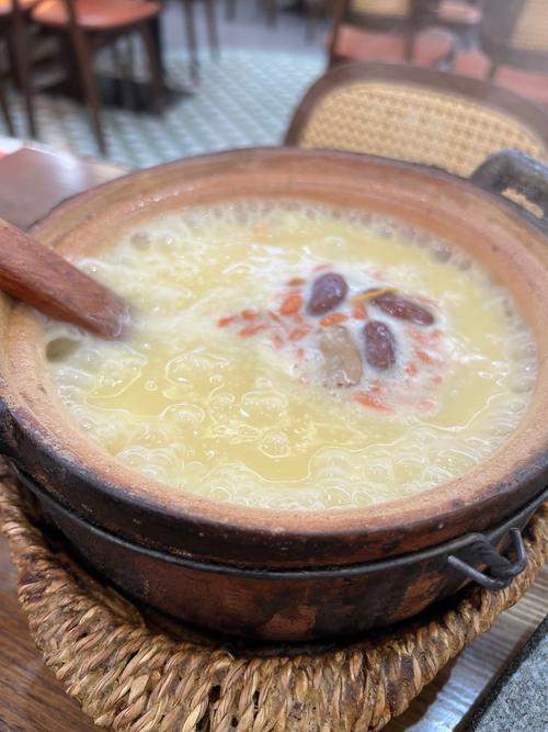 砂锅熬煮冒着热气的杂粮粥成品图