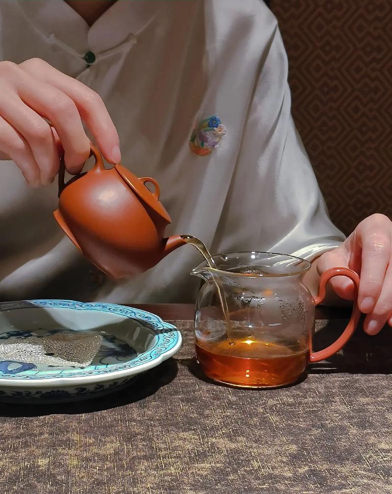 茶艺师双手捧紫砂壶专注冲泡特写