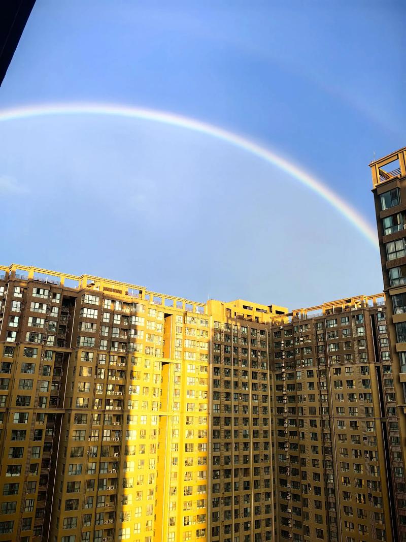 雷雨后城市住宅小区天空半弧形彩虹