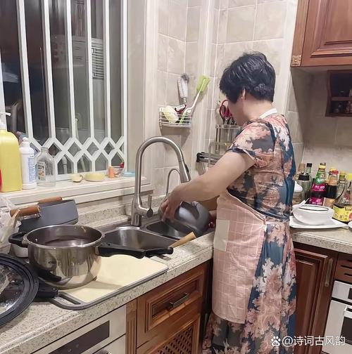 妈妈在厨房边做饭边用手机收听播客的温馨背影