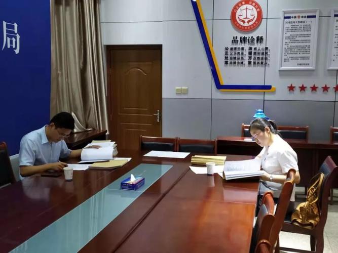 中国法律援助律师在法院值班室匆忙准备辩护材料场景