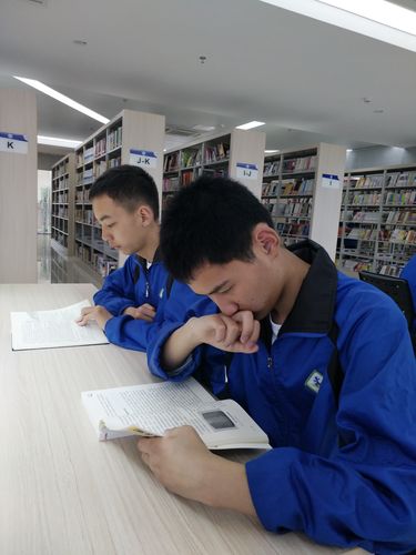 中学生趴在图书馆靠窗位置读专业物理书