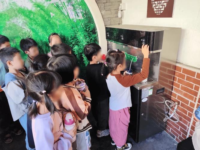 小学四年级学生课间观察饮水机接水场景
