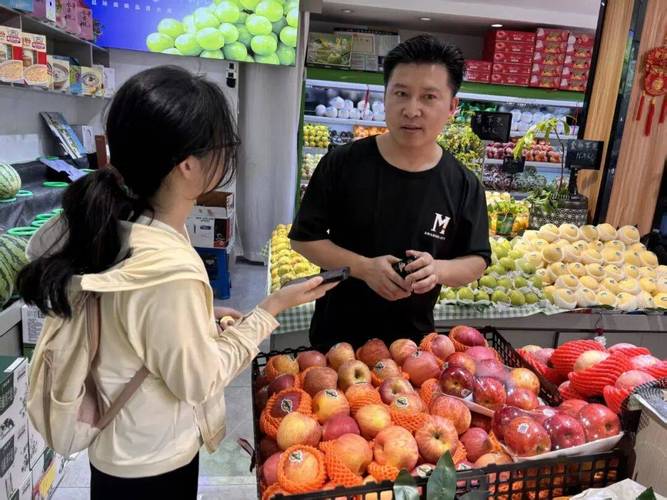 社区水果店老板和顾客沟通赔偿的实景图