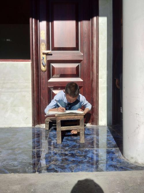 乡村小学门卫室蹲在地上攥老年机的小男孩